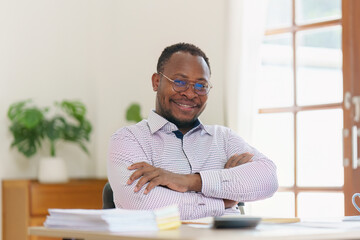 Wall Mural - Smiling American African makes financial report and studies annual figures, analyzes profits. Accountant checks status of financial