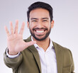 © Joanrae/peopleimages.com - Portrait, smile and Asian man with stop, hand and communication against grey studio background. Face Japanese male or guy with gesture for warning, sign language and welcome with opportunity or smile
