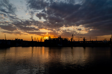 Wall Mural - sunset in industrial landscape of commercial seaport. Sunset at seaport.