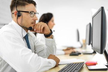 Wall Mural - Group of happy call center smiling business operator customer help support team phone services agen working and talking with headset on desktop computer at call center office