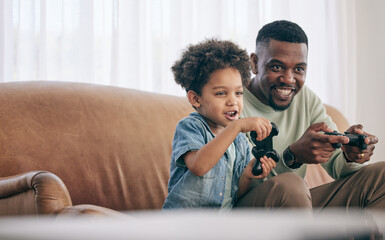 Wall Mural - Black family, dad and child playing video games on living room sofa together with controllers at home. Happy African American father with son with smile enjoying bonding time on console entertainment