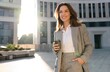© opolja - Beautiful Woman Standing With Coffee Near Office Building. Portrait Of Successful Woman Holding Cup Of Hot Drink.