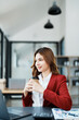 © Jirapong - Beautiful young teen asian businesswomen using computer laptop and drink coffee with in smile winner is gesture, Happy to be successful celebrating achievement success