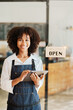 © Jirapong - Startup successful small business owner sme beauty girl stand with tablet in coffee shop restaurant, asian tan woman barista cafe owner, entrepreneur seller business concept