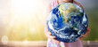 earth day concept, A child holds the world on arid natural sky background.