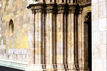 beautiful carved layered stone church door frame. richly decorated stone posts with ornate elements. circular window. gothic architecture. perspective view. the  Matthias church entrance in Budapest.