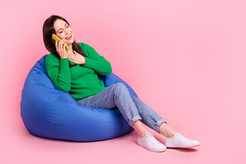 Sticker - Full length portrait of cheerful positive person sit comfort bag speak communicate telephone laughing isolated on pink color background