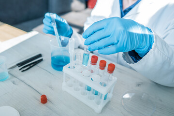 Wall Mural - Medical research laboratory. A scientist works with a pipette and a test tube. Scientific laboratory of biotechnology, development of medicine and research in chemistry, biochemistry and experiments.