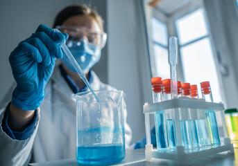 Wall Mural - Medical research laboratory. A scientist works with a pipette and a test tube. Scientific laboratory of biotechnology, development of medicine and research in chemistry, biochemistry and experiments.