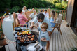 © Halfpoint - Father with little son grilling outside during family summer garden party.