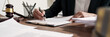 © mojo_cp - Lawyer preparing to sign a contract and wooden gavel on table justice and law concept.