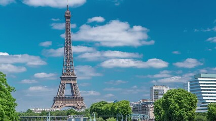 Canvas Print - Eiffel tower at the river Seine timelapse from Grenelle bridge in Paris, France. Isle of the Swans and ship on river at sunny summer day under white clouds