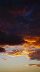 Wall Mural - timelapse with dramatic red sunset on dark cloudy sky. vertical video