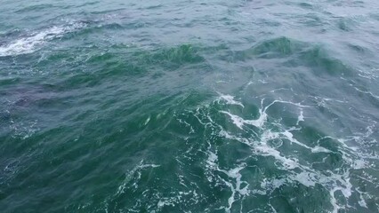 Wall Mural - Aerial view from above of the sea waves at the rocky shore. Ocean coast. Calm beautiful video on the background for tourism, design and advertising