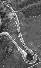 Wall Mural - Vertical panorama of a windy mountain road across the Alps in au