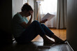 © spyrakot - Silhouette of a sad woman sitting on the floor of her apartment