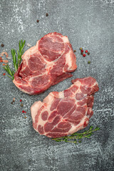 Canvas Print - raw pork steaks on a cutting board with spices Raw meat pork steaks with seasoning. place for text, top view