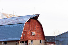 A Red Barn With A Blue Peaked Roof And A Home-made American Flag Made Of Pallets.