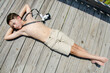 © 3Days2Go Media - Young preteen boy laying on sunny boardwalk with camera