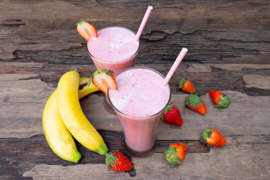 Fototapete - Strawberry and banana smoothie colorful fruit juice milkshake blend beverage healthy high protein the taste yummy In glass drink episode morning on a wooden background.