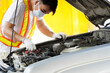 © Apicha - Asian mechanic examining the car's symptoms.service concept