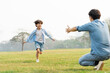 © Q88 - image of an asian father and son having fun in the park