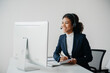 © laddawan - Serious call center operator in wireless headset talking with customer, woman in headphones with microphone consulting client on phone in customer support service in office