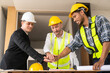 © ArLawKa - Businessman shaking hands with engineers in construction, construction site renovation concept, architect engineer inspecting workplace for project real estate