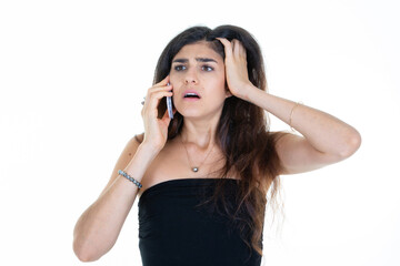 Wall Mural - brunette surprised woman hearing bad news on the phone with hand in hair talking on cell smartphone on white background