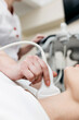 © wedmoments.stock - Ultrasound diagnosis of the thyroid gland of a young woman in the clinic. A female doctor holds an ultrasound probe along the patient's neck. Health concept.