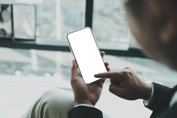 Wall Mural - Close up of men's hands holding cell telephone with blank copy space scree for your advertising text message or promotional content, hipster girl watching video on mobile phone during coffee break