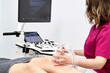 Doctor conducting ultrasound examination of patient's knee in clinic. High quality photo