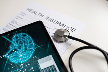 Modern social health insurance program. Tablet computer with healthcare application interface on screen. Stethoscope, x-ray image and cardiogram on wooden desk. Digital healthcare technologies.
