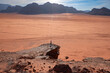 © robertharding - A person standing on a rock above the wide plain of Wadi Rum desert, UNESCO World Heritage Site, Jordan