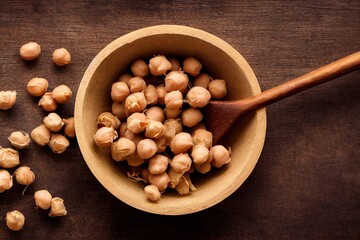 Wall Mural - Round light brown chickpeas seeds in wooden bowl with wooden spoon, created with generative ai