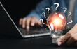 © Pakin - Businessman holding glowing light bulb with question icon. Find answers online. FAQ search for information on the internet