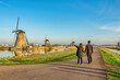 © Noppasinw - Dutch Windmill landscape at Kinderdijk Village Netherlands with love couple walking