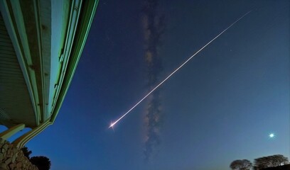 Sticker -  an airplane flying in the night sky with a streak of smoke coming from it's tail and the moon in the distance with a house in the foreground.  generative ai