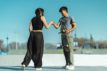 Boy And Girl Skaters Greeting With Handshake Punch In The Skate Park
