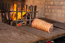 Flank Steak, Sirloin Steak And Filet Mignon Rolled Into A Single Piece With A Proper Rope Being Roasted In A Gaucho Traditional Parrilla Barbecue Grill In A Rustic Restaurant