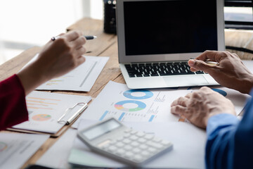 Two businessmen are reviewing monthly sales documents for analysis and marketing plans for more sales growth, they are the founders of young companies co-founding startups. Sales management concept.