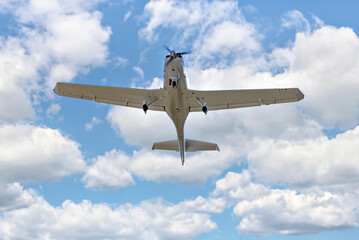 Wall Mural - Single engine ultralight plane flying in the blue sky with white clouds	