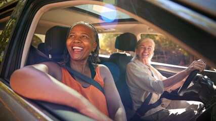 Wall Mural - Two Senior Female Friends Enjoying Day Trip Out Driving In Car Together