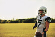 © Flamingo Images - Quarterback standing on a field with a football