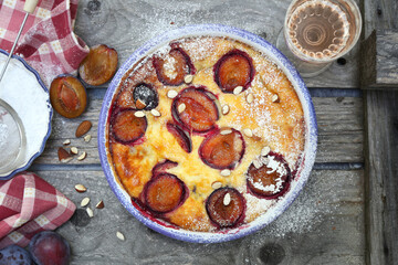 Wall Mural - Damson blue plum clafoutis (flan) and glass of rose wine, icing sugar and almonds dressing, french cuisine