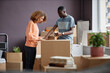 © Seventyfour - Young couple packing boxes together with adhesive tape during moving to a new house