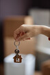 © Seventyfour - Vertical image of young woman holding keys from her new apartment