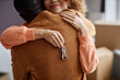 © Seventyfour - Happy couple embracing and congratulating each other, they getting keys from new apartment