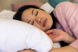 © Wavebreak Media - Happy asian woman lying asleep on white pillow on her bed
