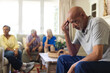 © Wavebreak Media - Group of emotional, diverse senior friends in living room, talking during group therapy session